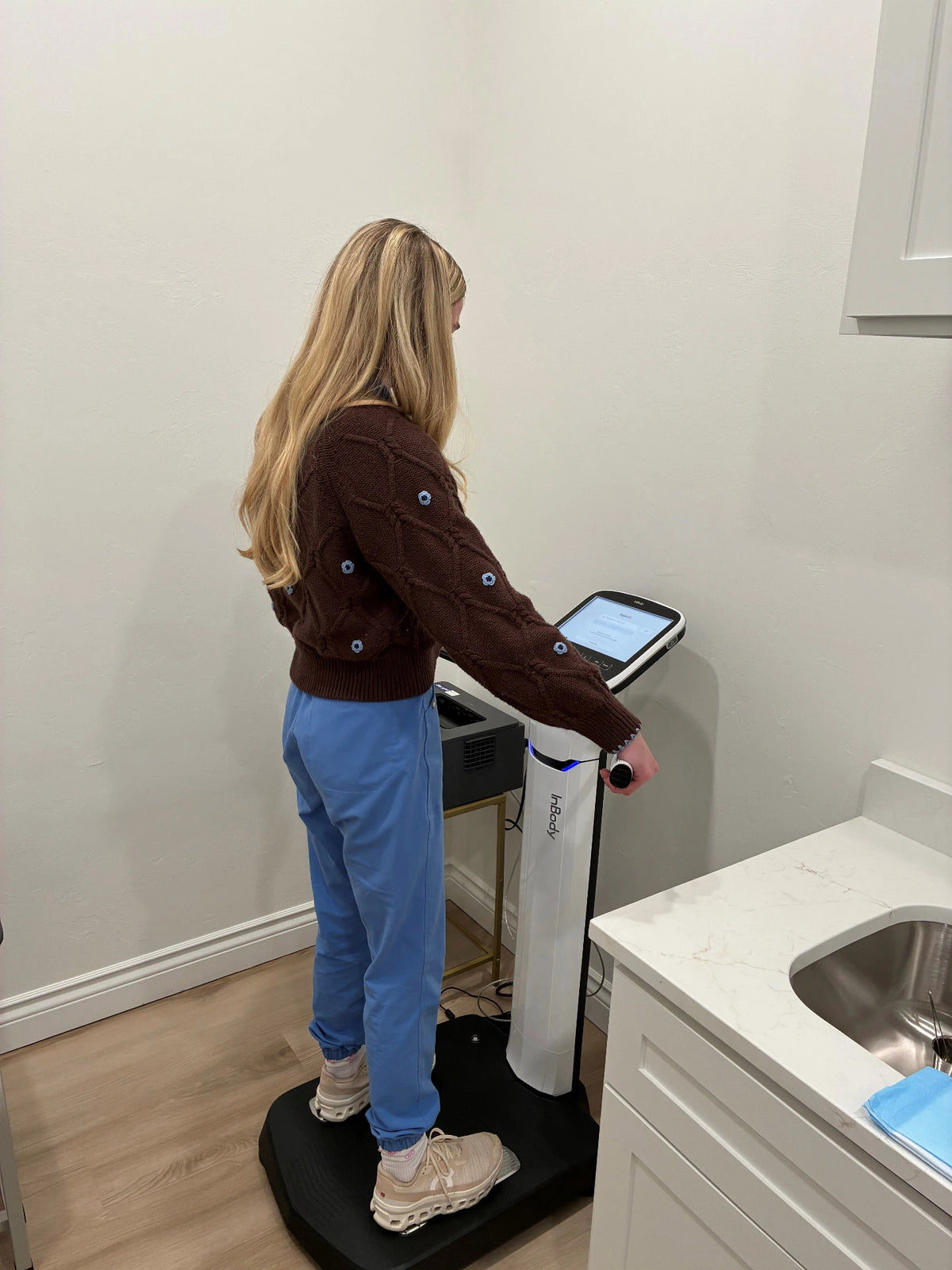 A patient standing on the InBody body-composition scanner during a quick scan at Pristine Health
