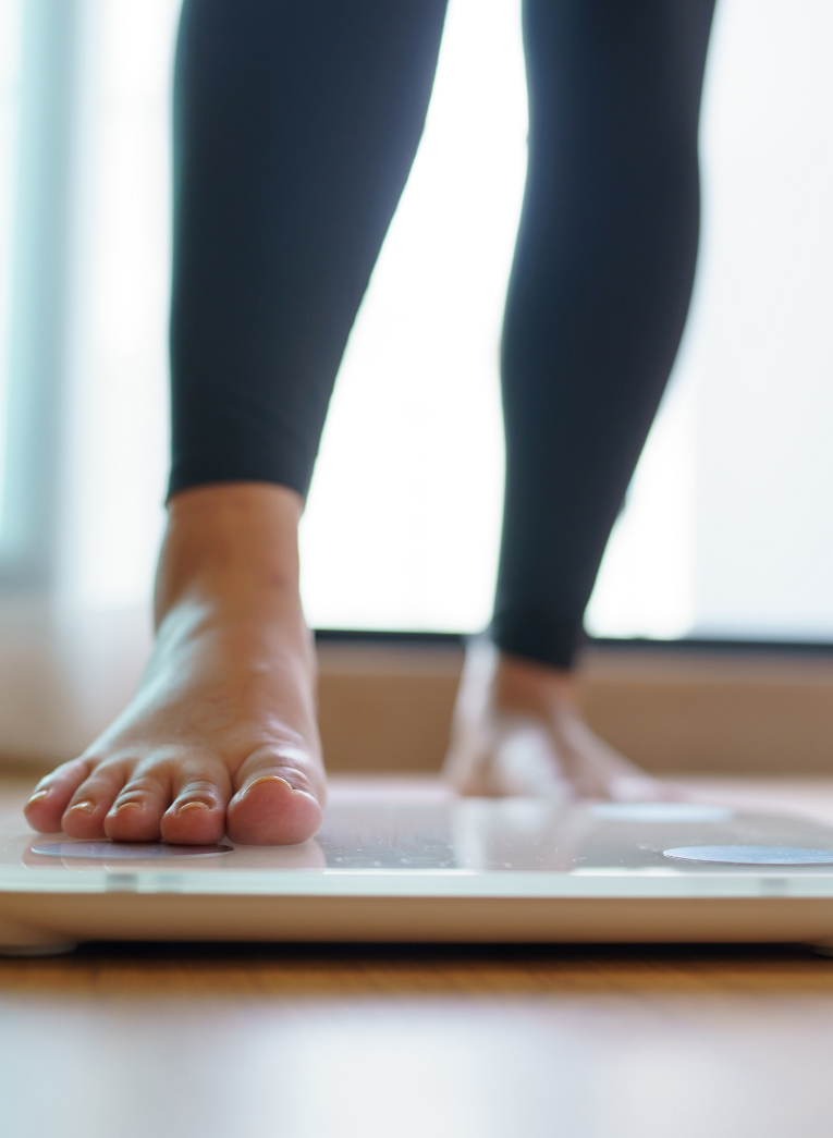 woman's foot stepping onto a scale