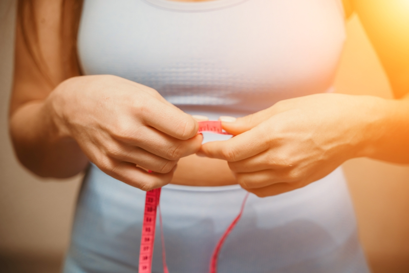 woman measuring waist line